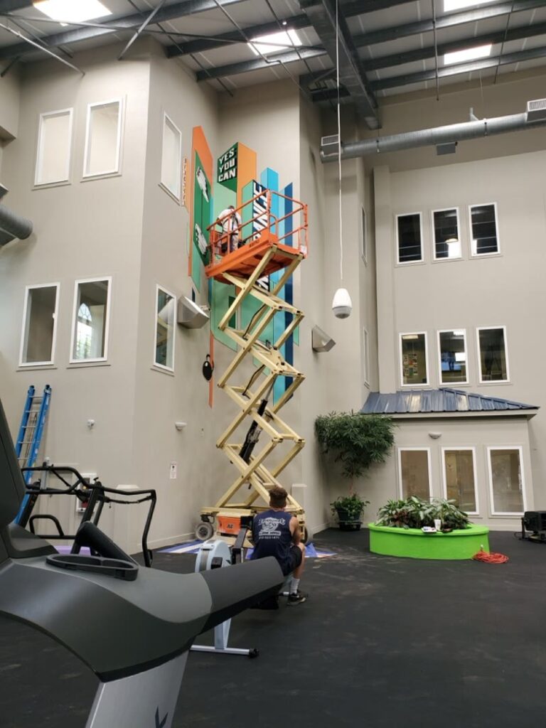 Journey Hallows working from a lift during installation of the Endurance mural