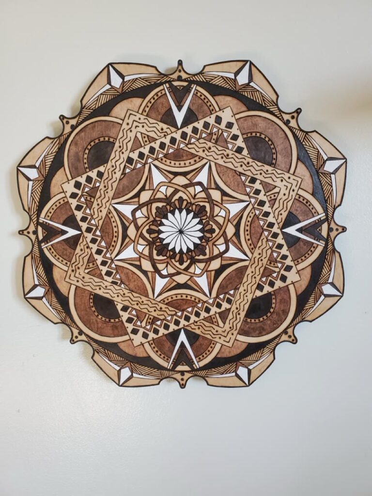 Front view of a detailed hand-burned geometric wood mandala