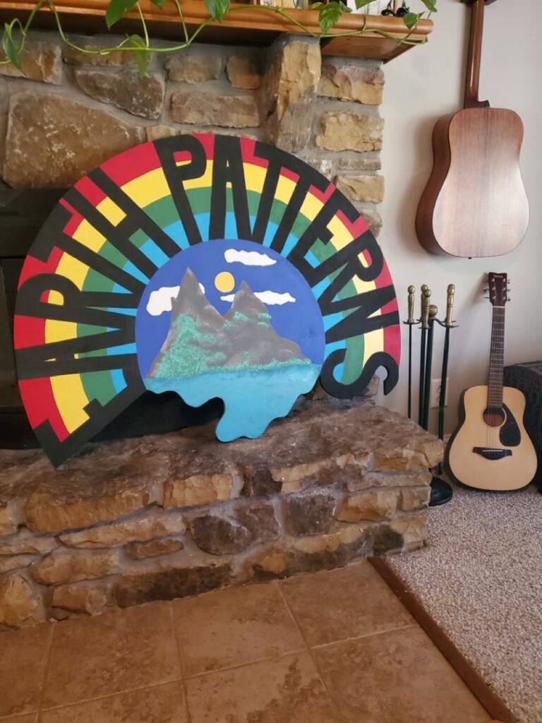 Hand-painted Happy Trails wood sign displayed on a stone hearth