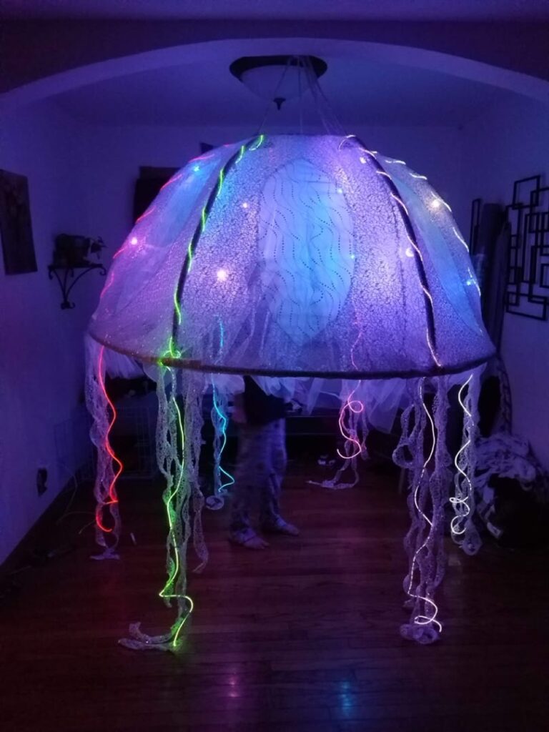 Jellyfish-inspired hanging installation illuminated in purple and blue
