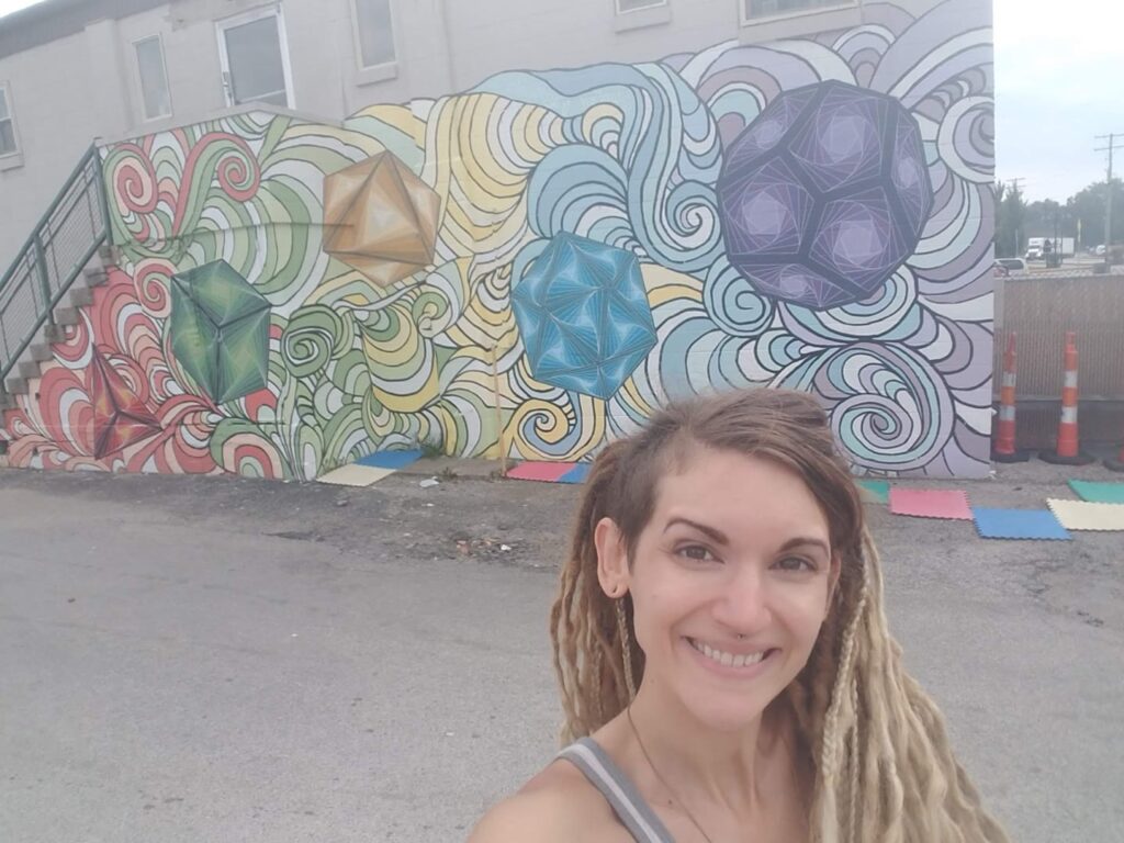 Journey Hallows standing in front of the completed Sacred Geometry mural
