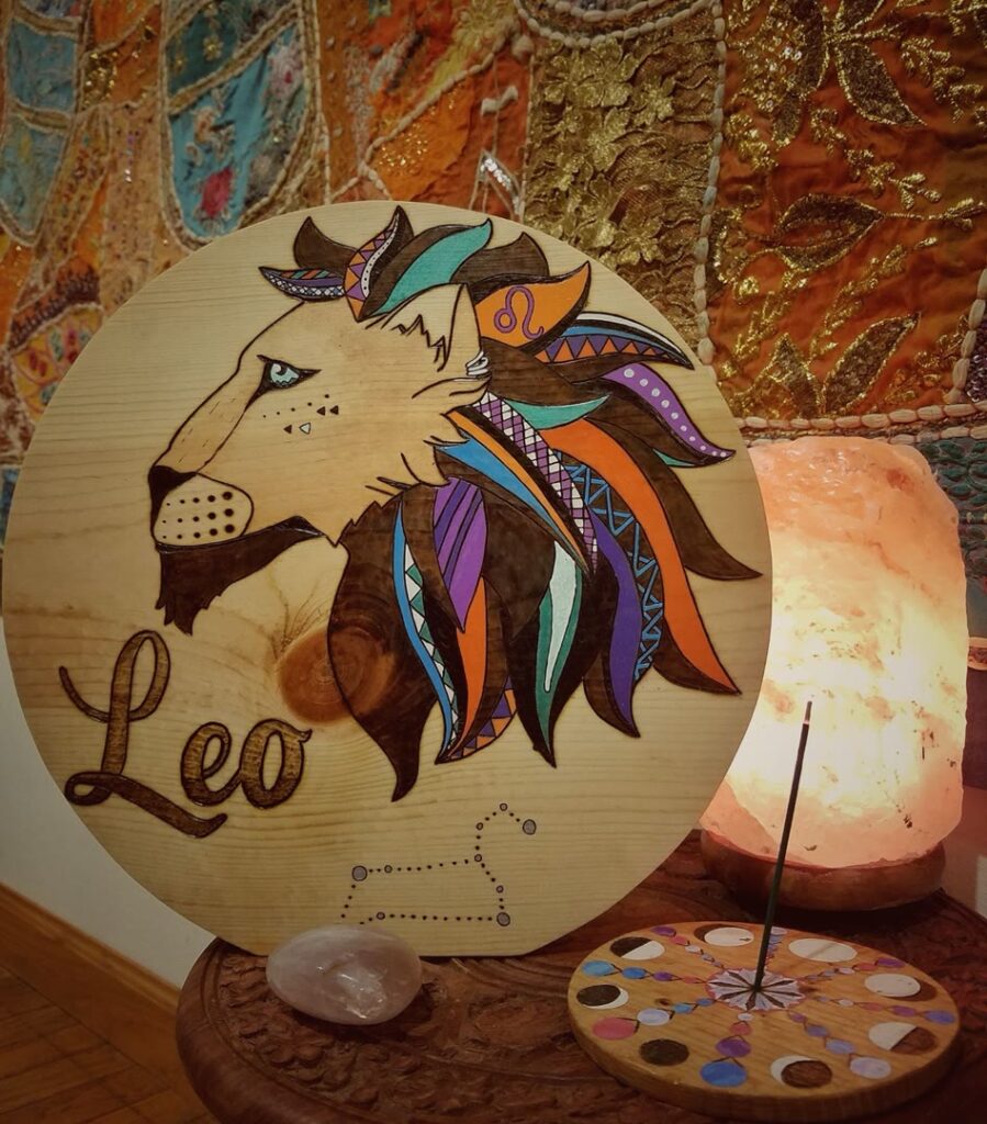 Hand-burned and painted Leo zodiac sign on round wood