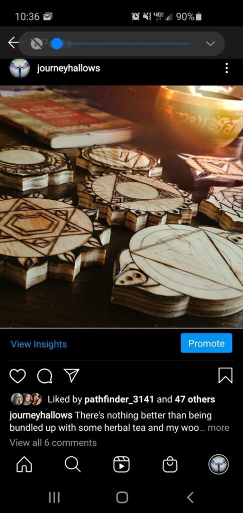 Collection of small hand-burned geometric wood pendants on a worktable